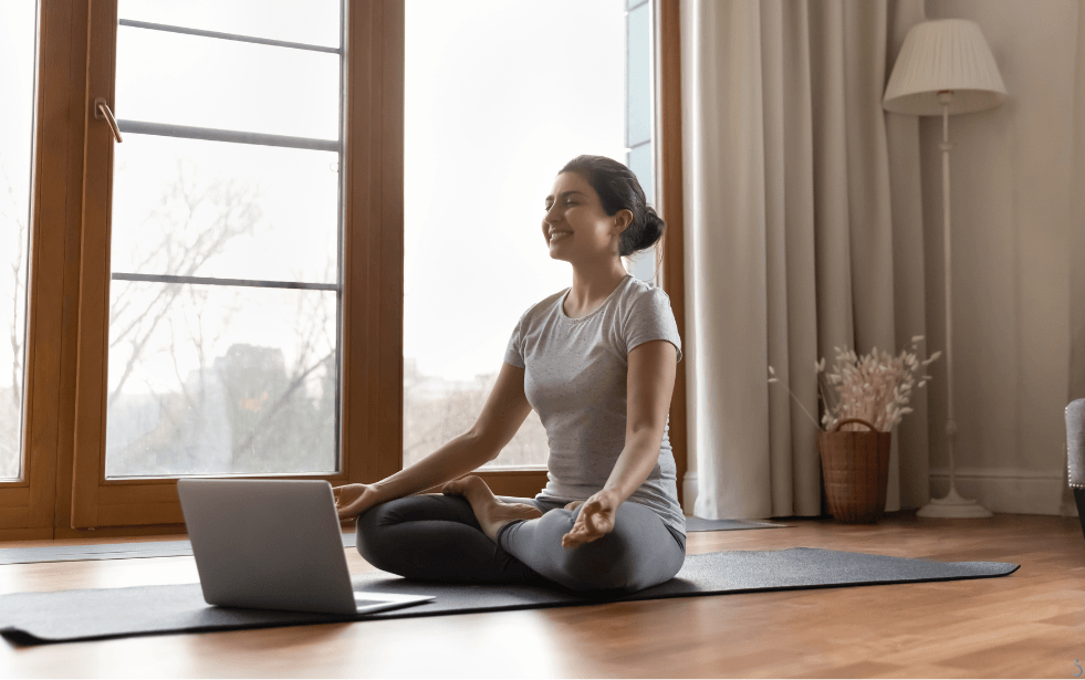 young-asian-healthy-woman-with-headphones-doing-exercise-indoor-home-stretching-her-arms-living-room-sitting-yoga-mat